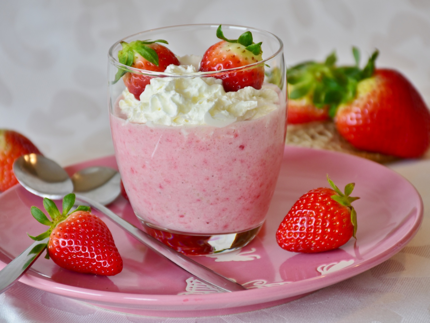 Ягоды клубники со взбитыми сливками на столе 