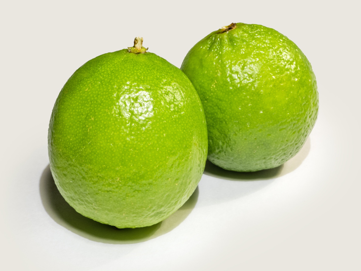 Два больших зеленых лайма на столе