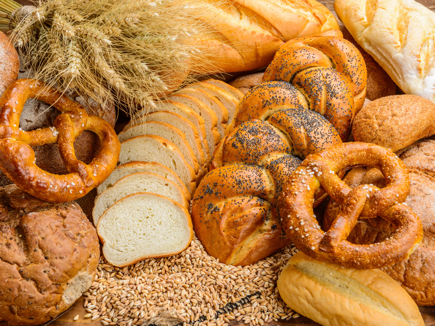 Свежая выпечка на столе с колосьями и зернами пшеницы 