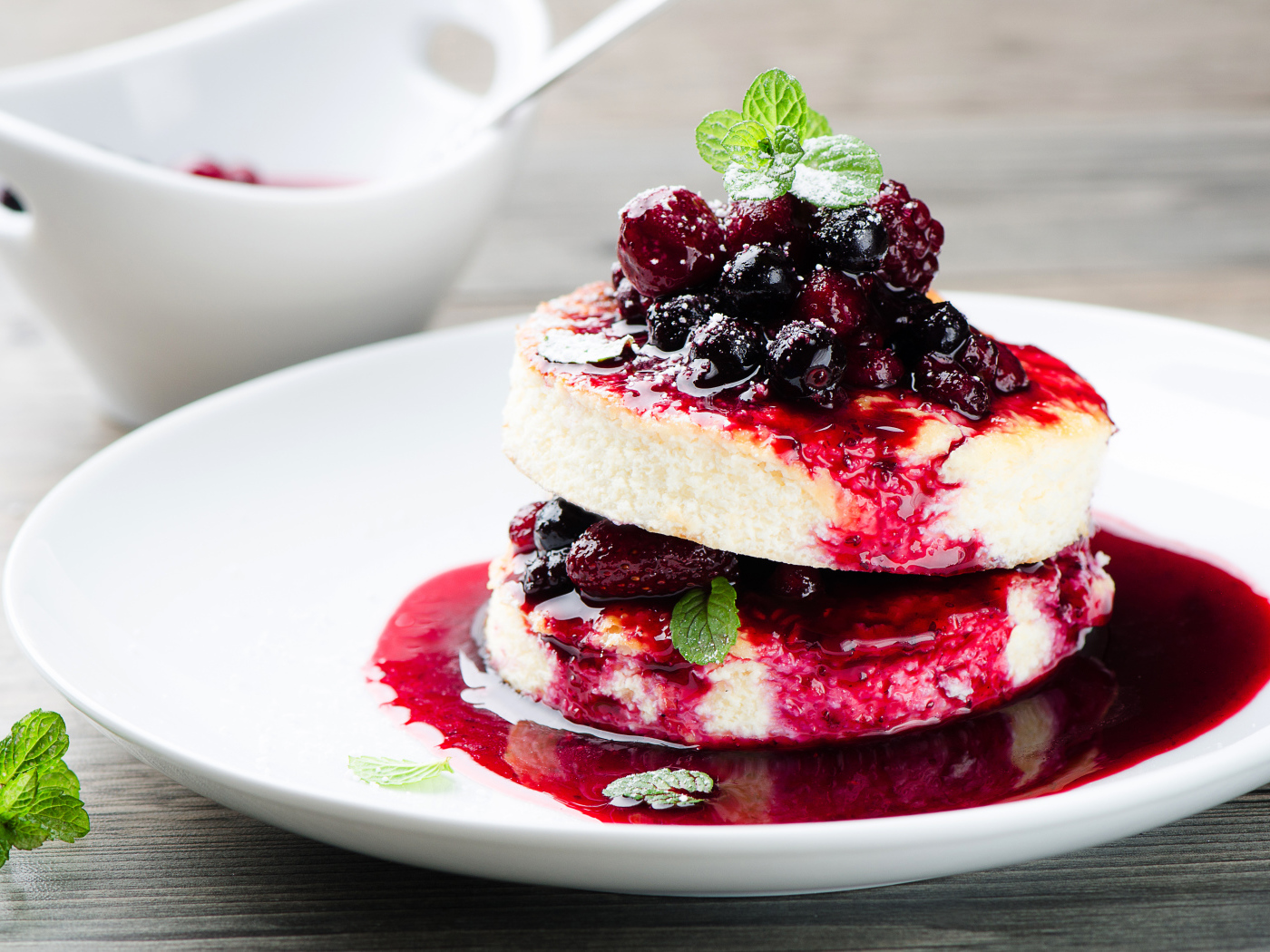 Аппетитные сырники с ягодами на белой тарелке 