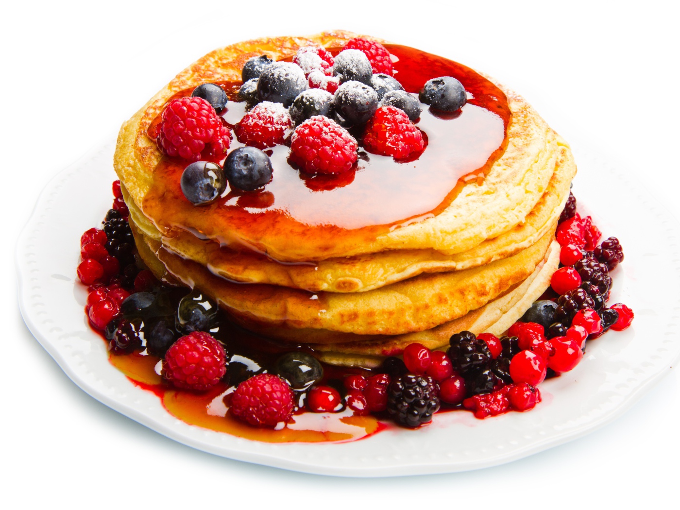 Оладьи с медом и ягодами малины и черники на белом фоне
