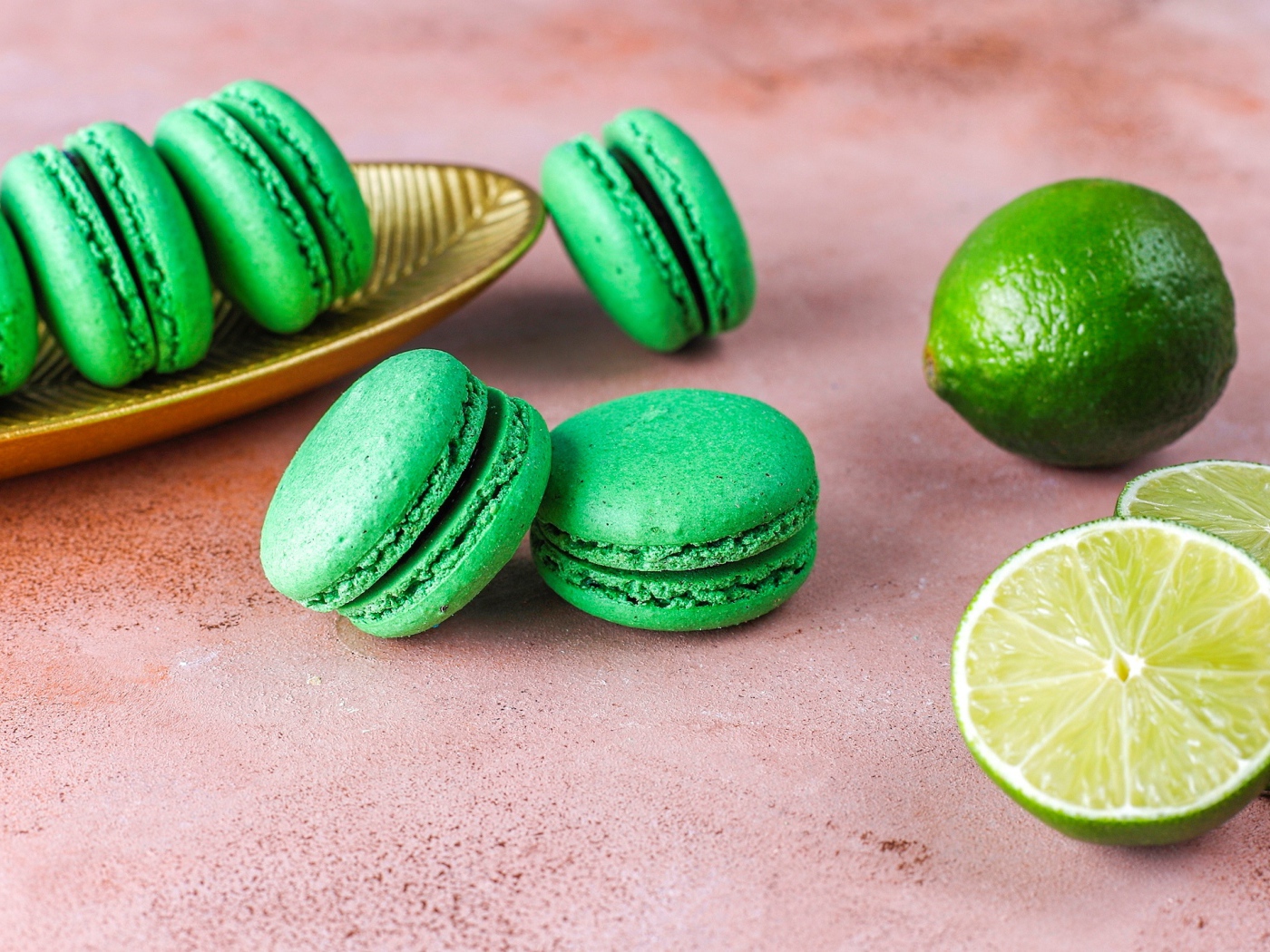 Зеленый десерт макарун на столе с лаймом
