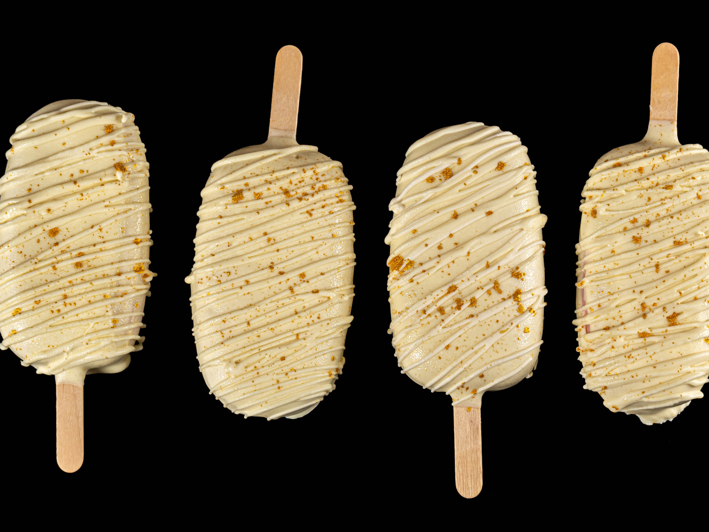 Мороженое на палочке в белом шоколаде на черном фоне