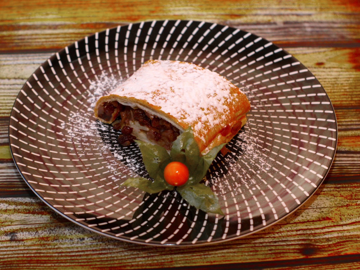 Кусок яблочного штруделя на тарелке 