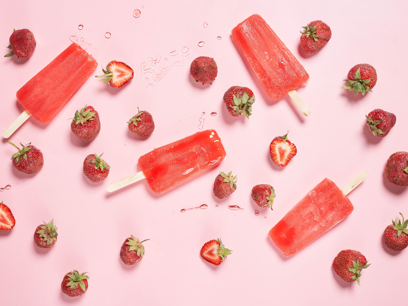 Фруктовое мороженое на розовом фоне с ягодами клубники 