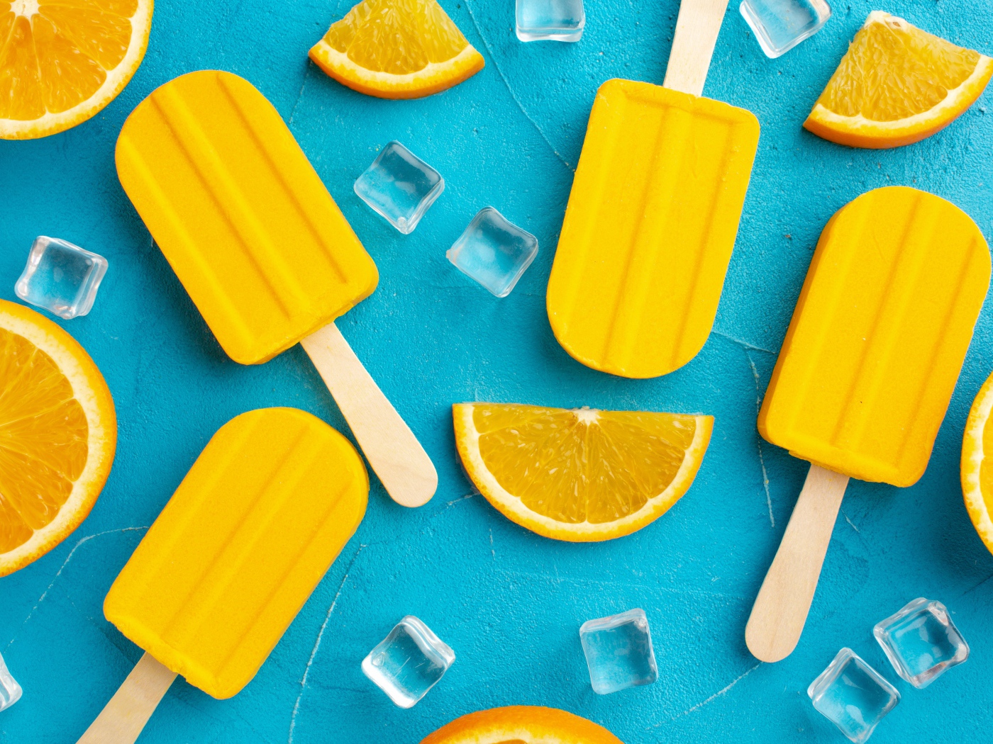 Фруктовое мороженое с кусочками льда и апельсина на голубом столе 