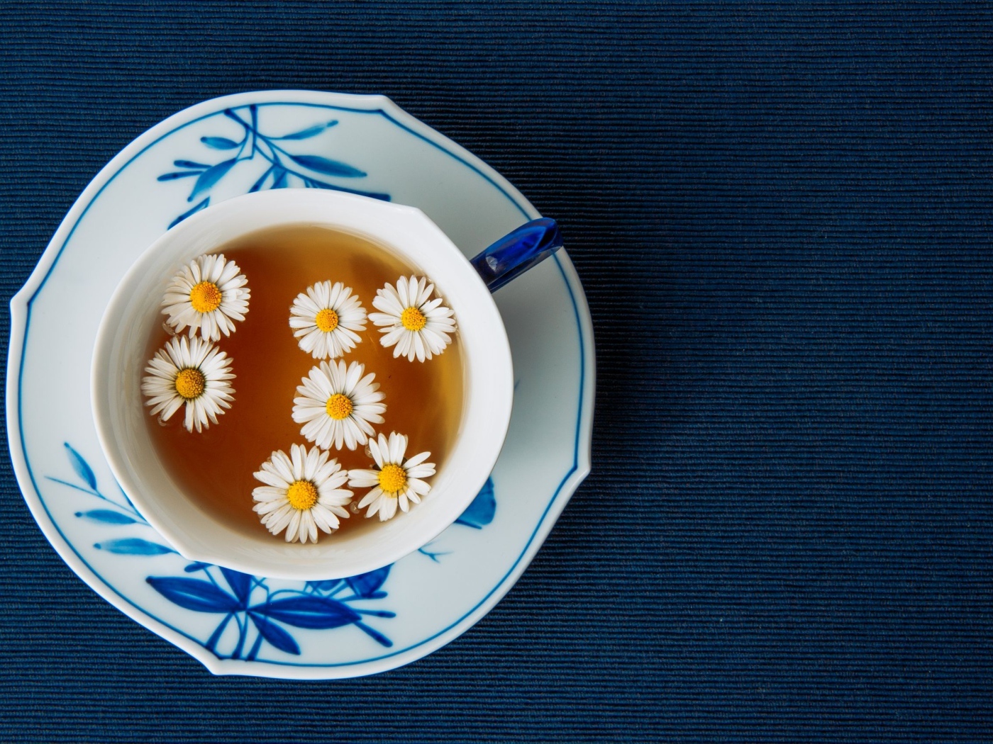 Чашка горячего чая с ромашкой на столе