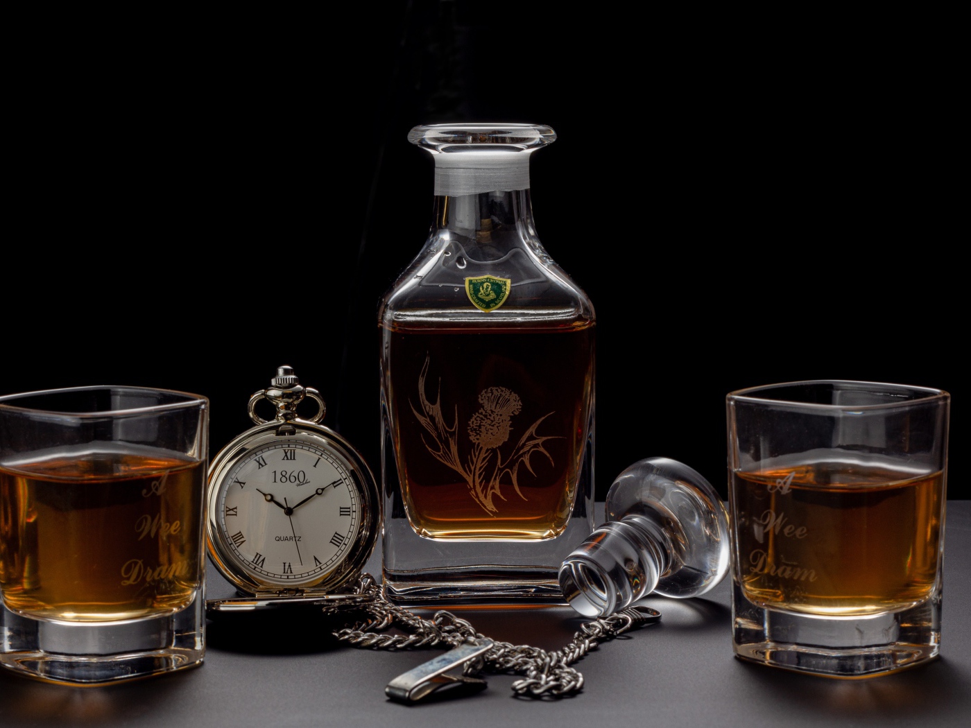 Дорогой коньяк на столе с карманными часами 