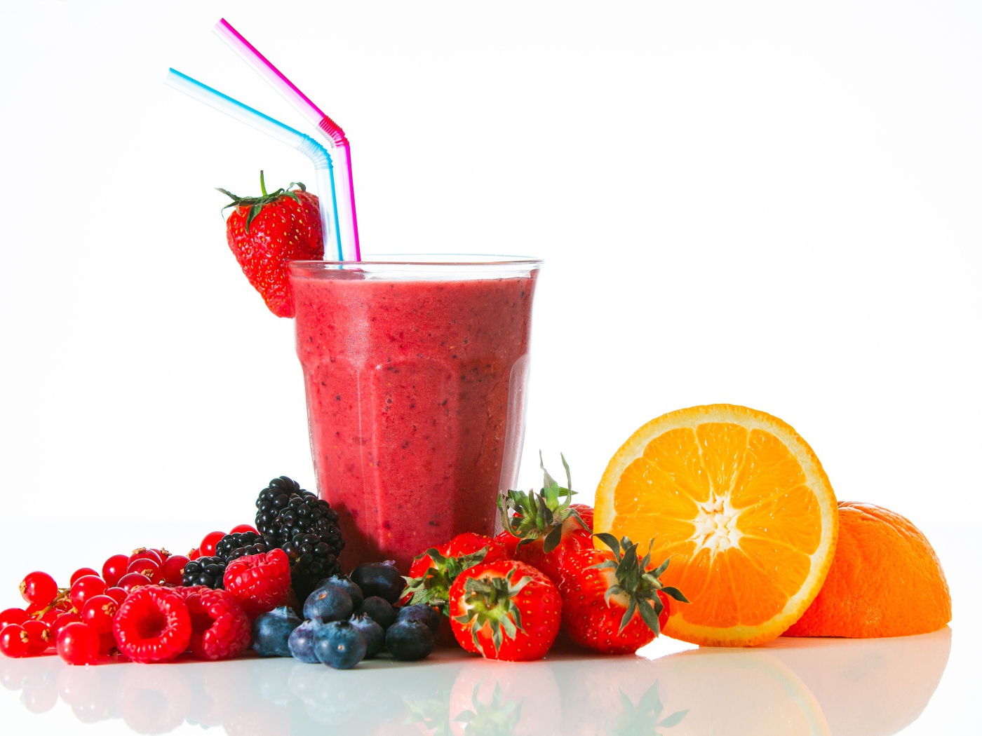 Стакан свежего смузи на столе с ягодами