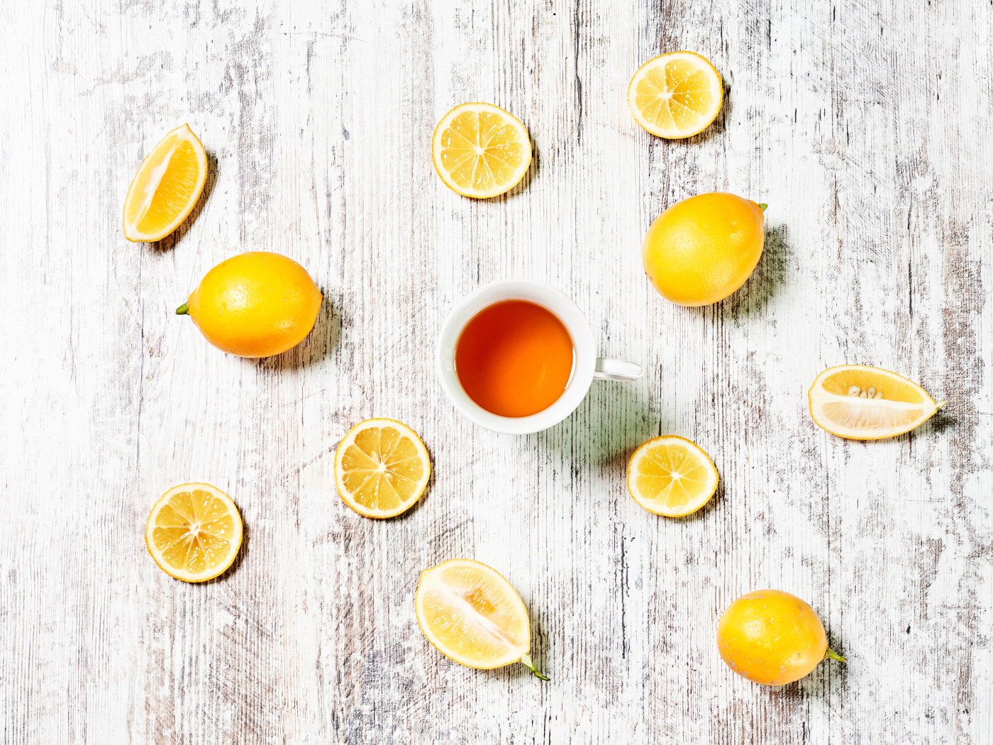 Желтые лимоны с чаем на белом столе 