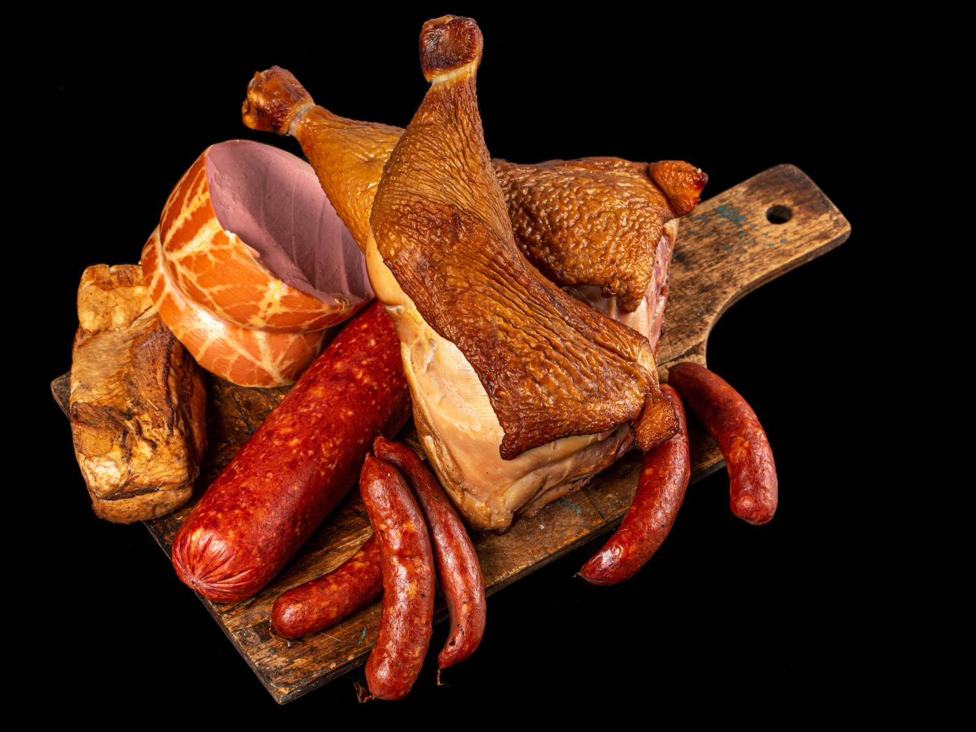 Appetizing smoked meats and sausage on a black background