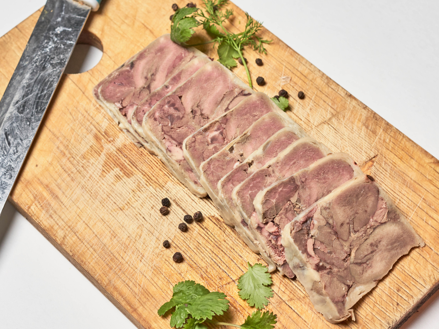 Мясной продукт на деревянной доске с ножом 