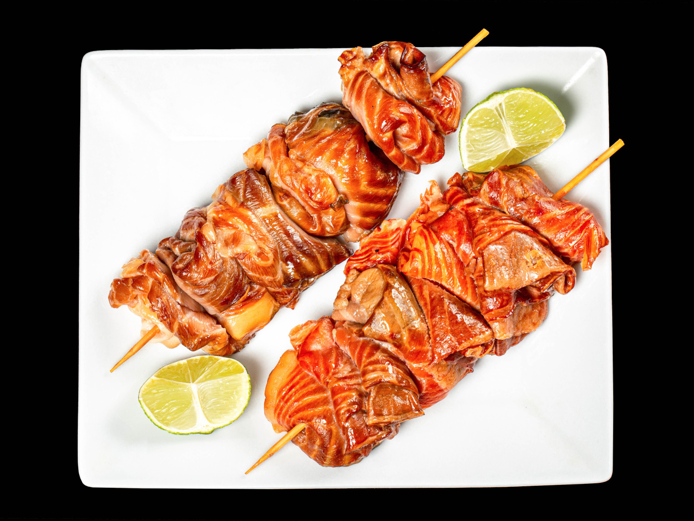 Шашлык на шпажках на белой тарелке с лимоном