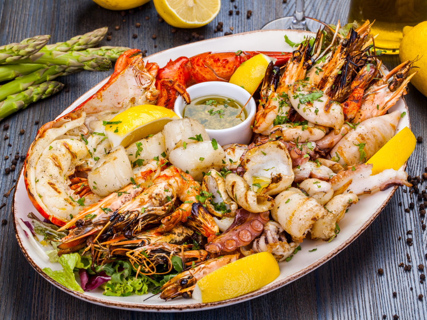 Запеченные морепродукты на тарелке с лимоном 