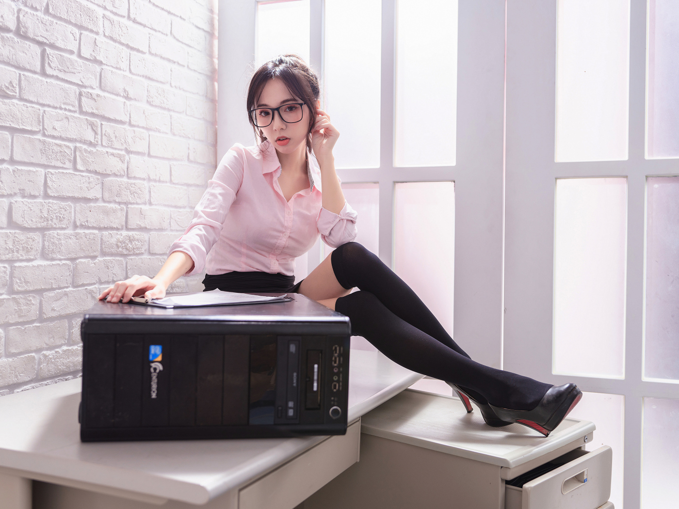 Девушка азиатка в черных чулках с системным блоком