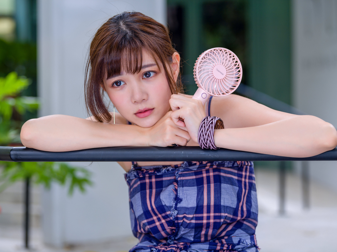 Девушка азиатка с вентилятором в руке 