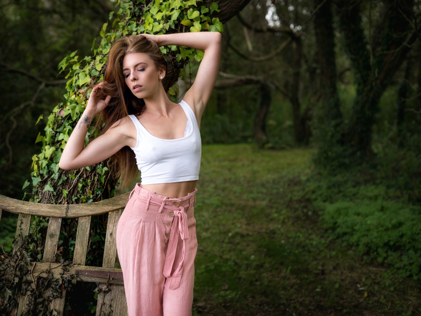 Красивая стройная девушка стоит у дерева 