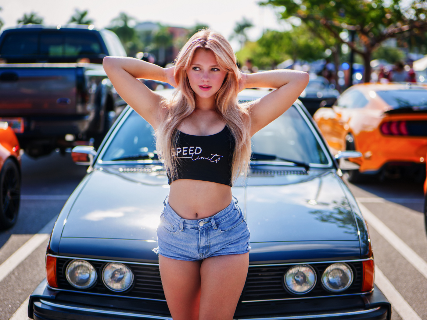 Красивая молодая блондинка в шортах у машины
