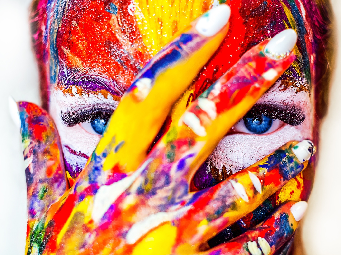 Голубоглазая девушка с лицом в краске на белом фоне