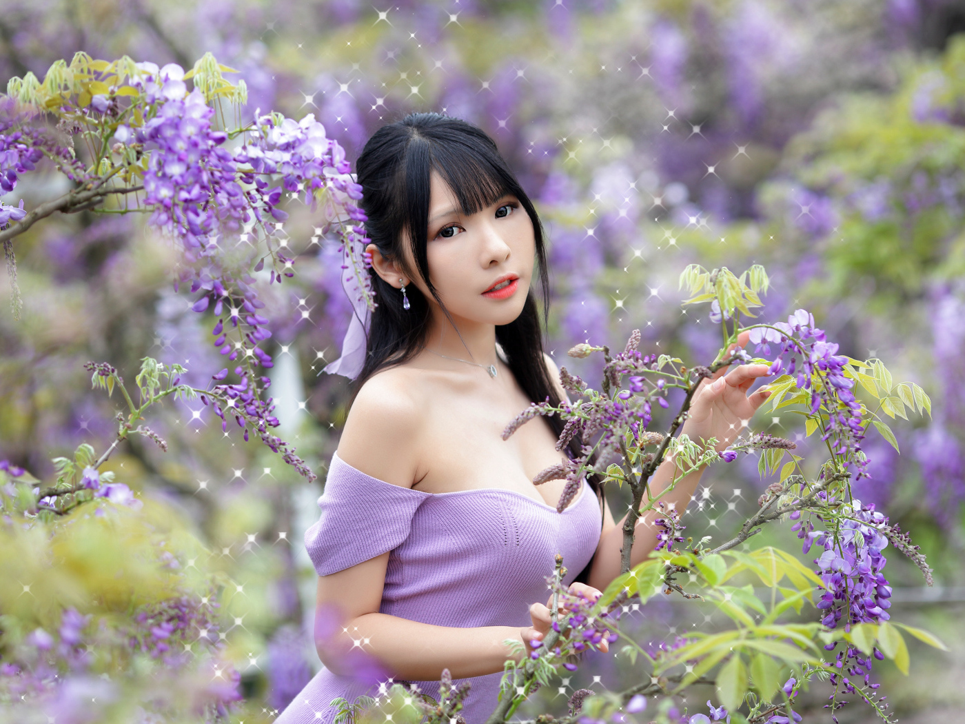 Кареглазая азиатка у куста с цветами глицинии