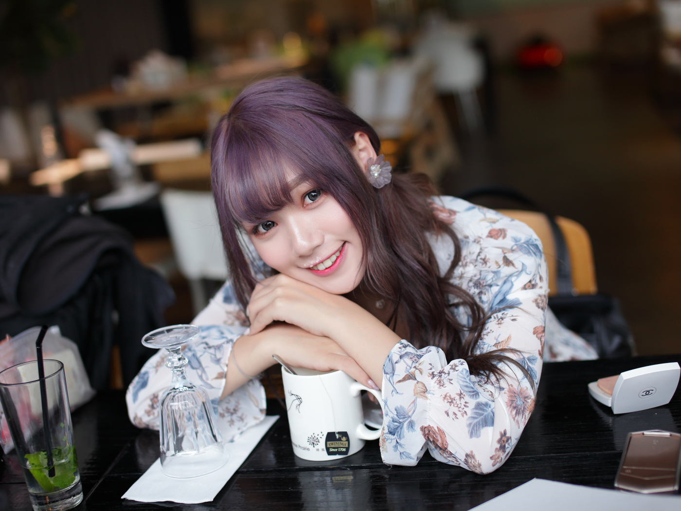 Милая девушка азиатка сидит за столиком