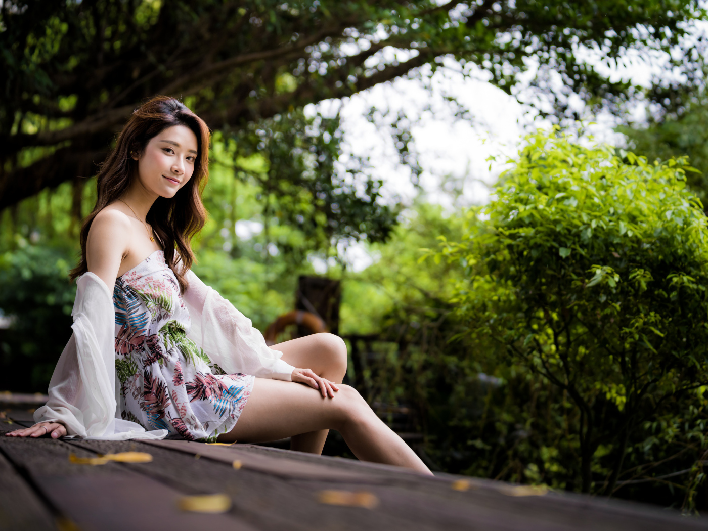 Милая девушка азиатка сидит на мосту