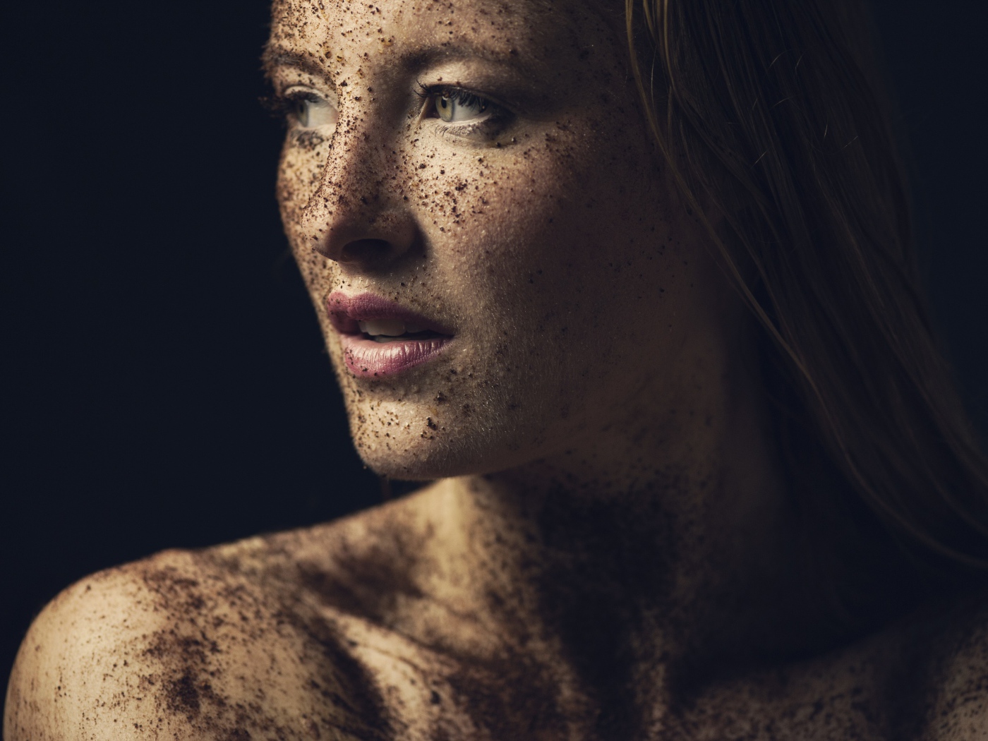 Грязная девушка в земле на черном фоне