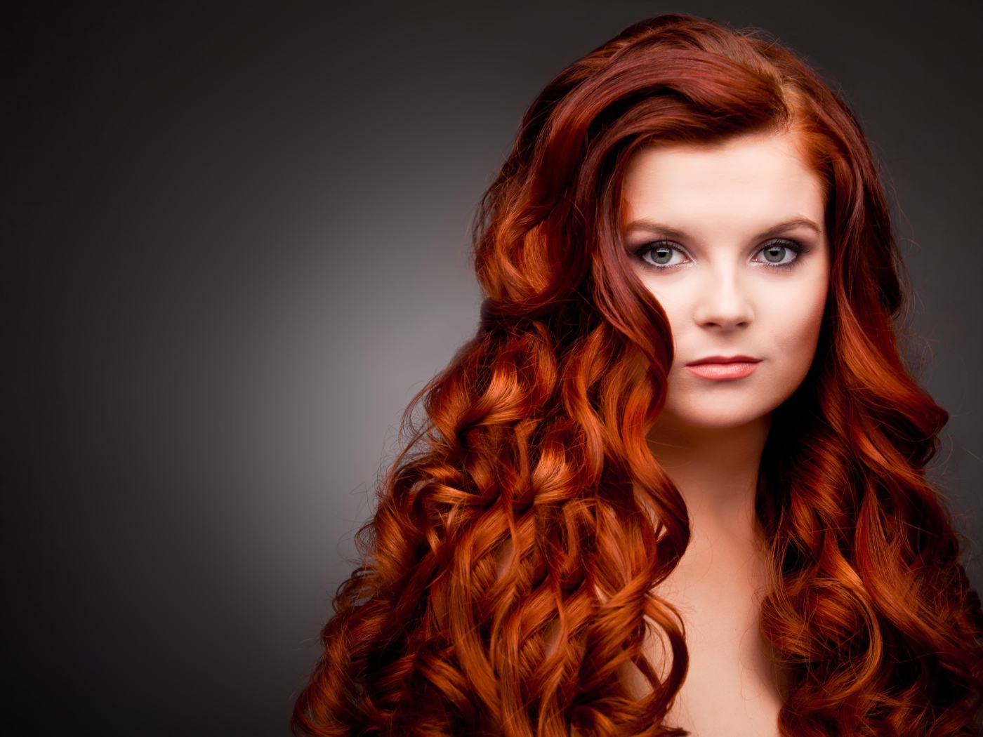 Длинные ярко рыжие волосы у красивой девушки 