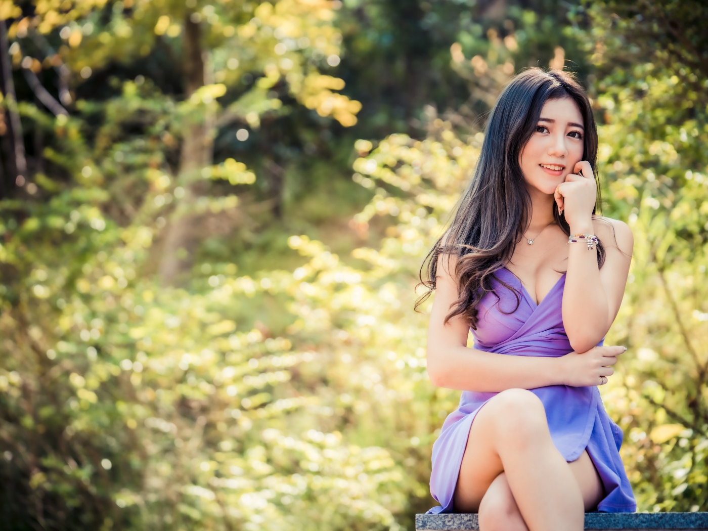 Улыбающаяся девушка азиатка в сиреневом платье