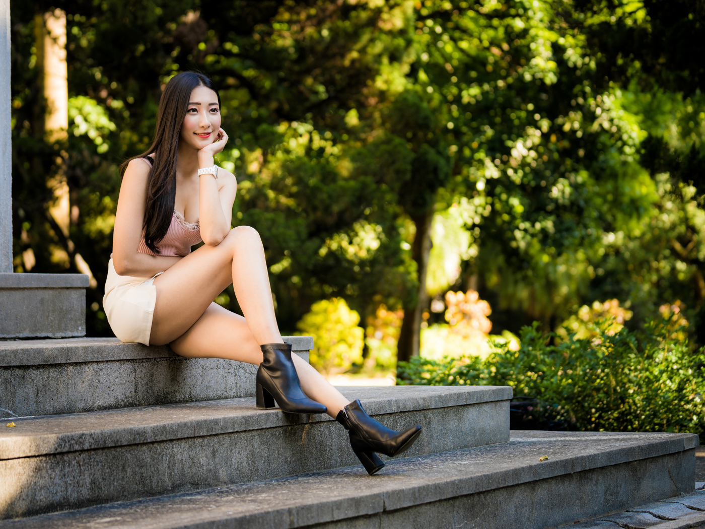 Улыбающаяся азиатка сидит на ступеньках