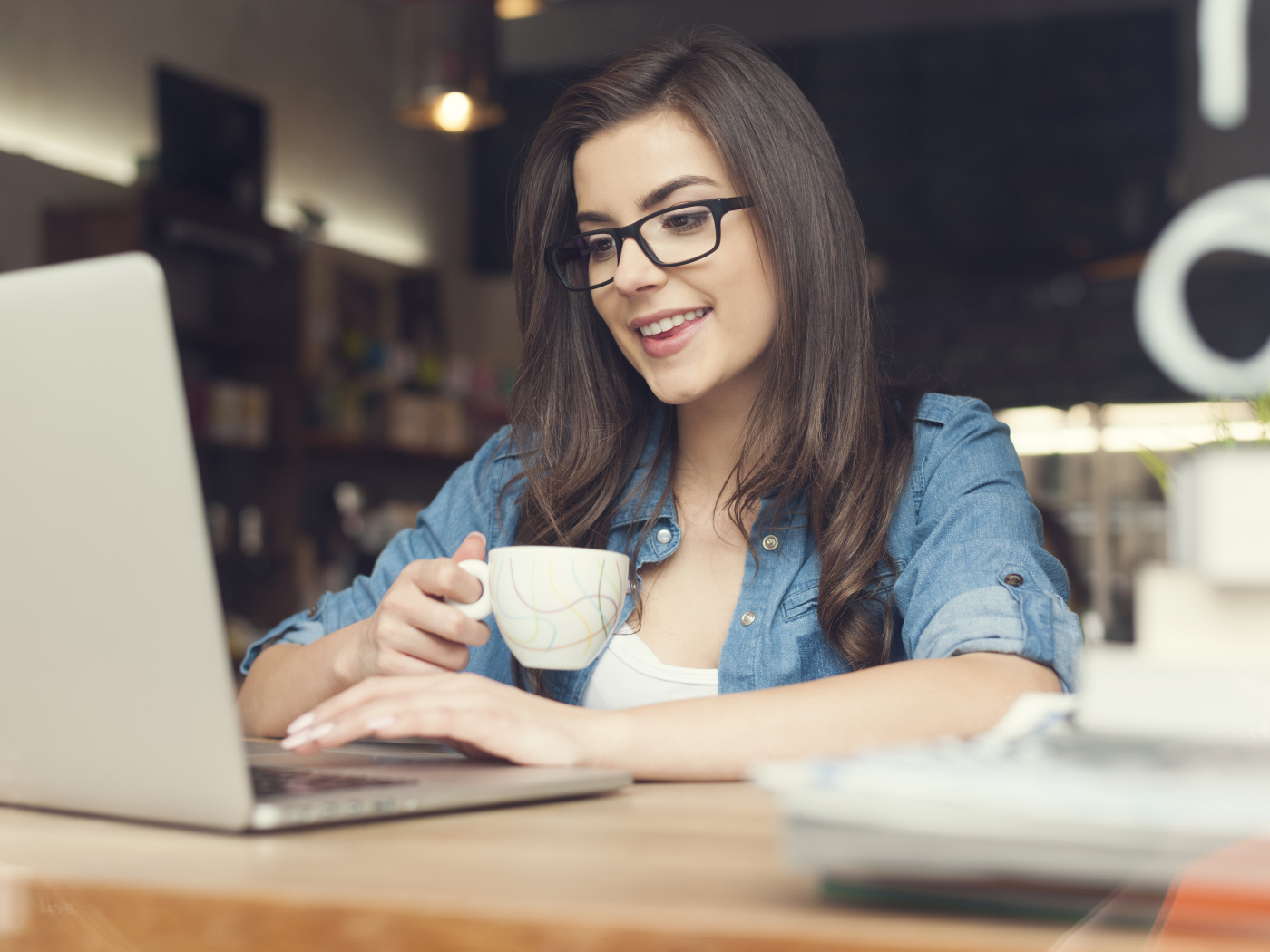 Улыбающаяся девушка в очках с ноутбуком