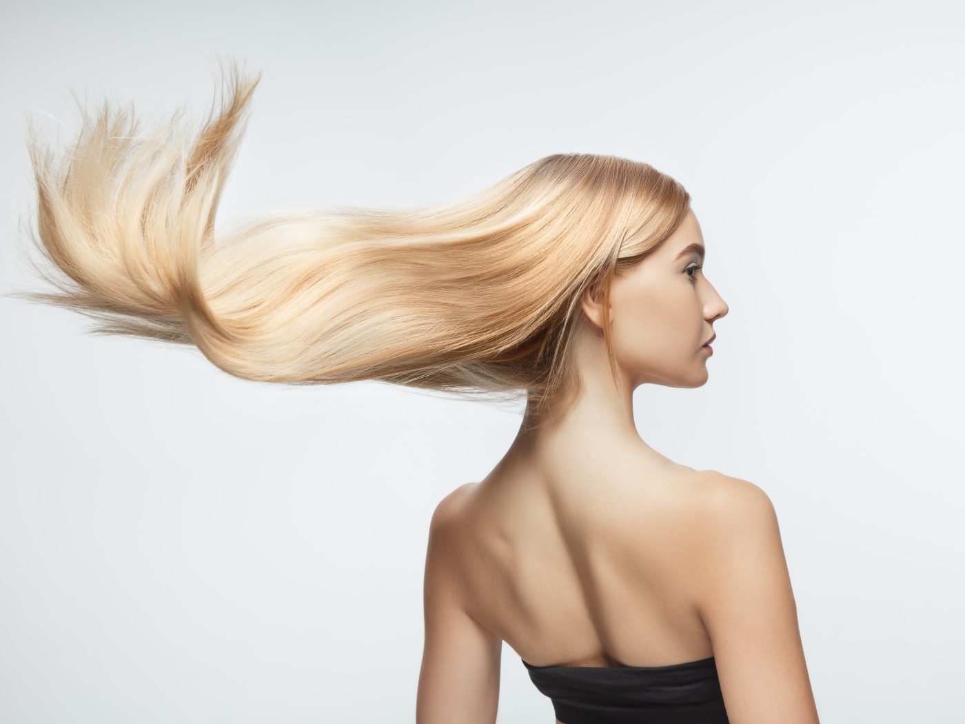 Белые волосы девушки развиваются на белом фоне 