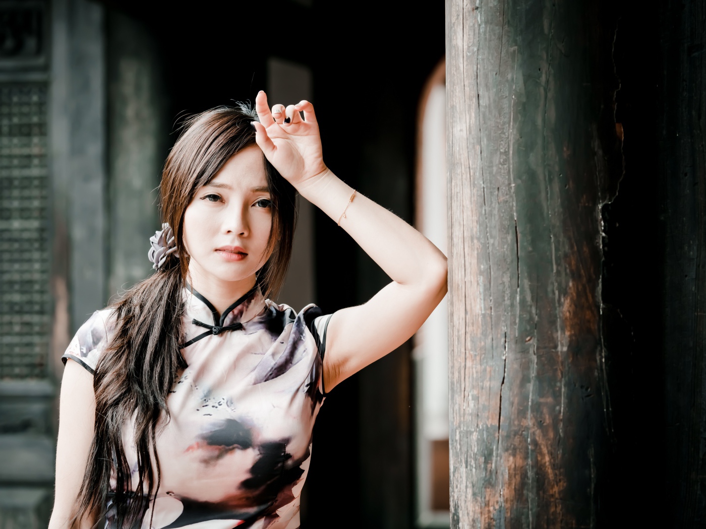 Молодая девушка азиатка стоит у столба 