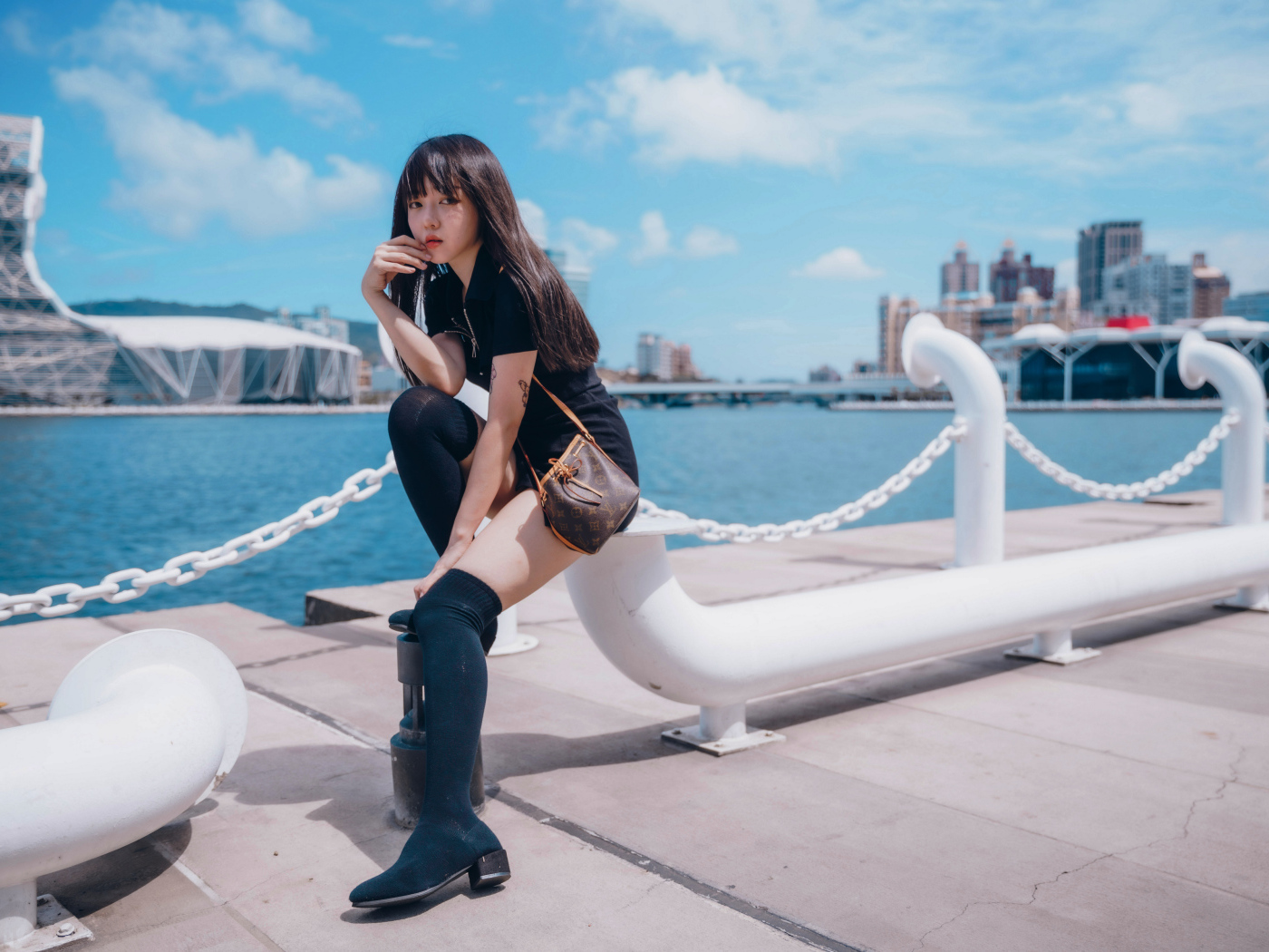 Молодая азиатка сидит в порту 