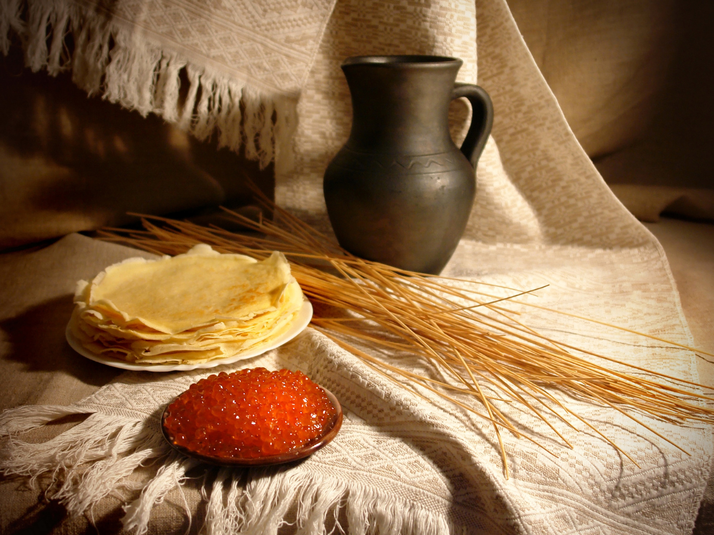 Блины с икрой на столе с колосьями на праздник Масленица