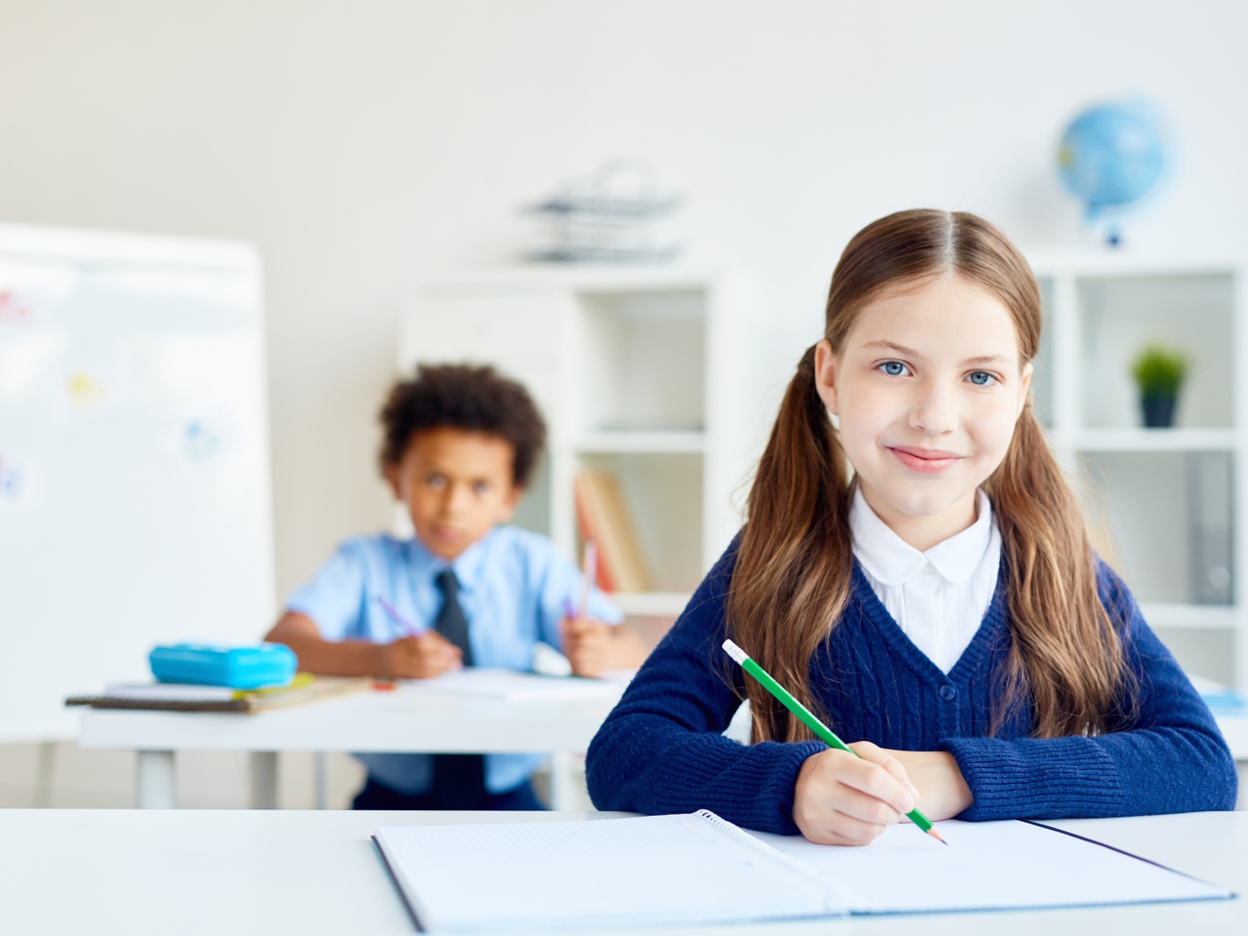 Девочка школьница сидит за партой в школе 