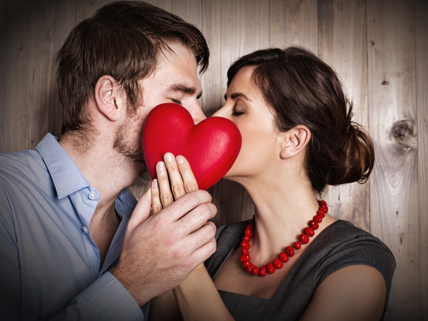 Поцелуй влюбленной пары за красным сердцем