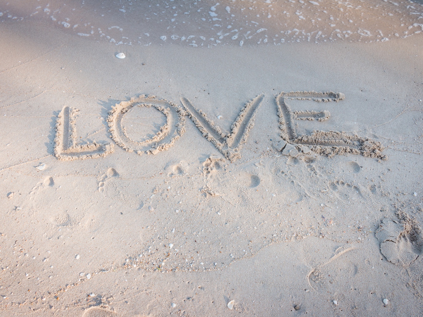 Надпись Любовь на мокром песке у моря