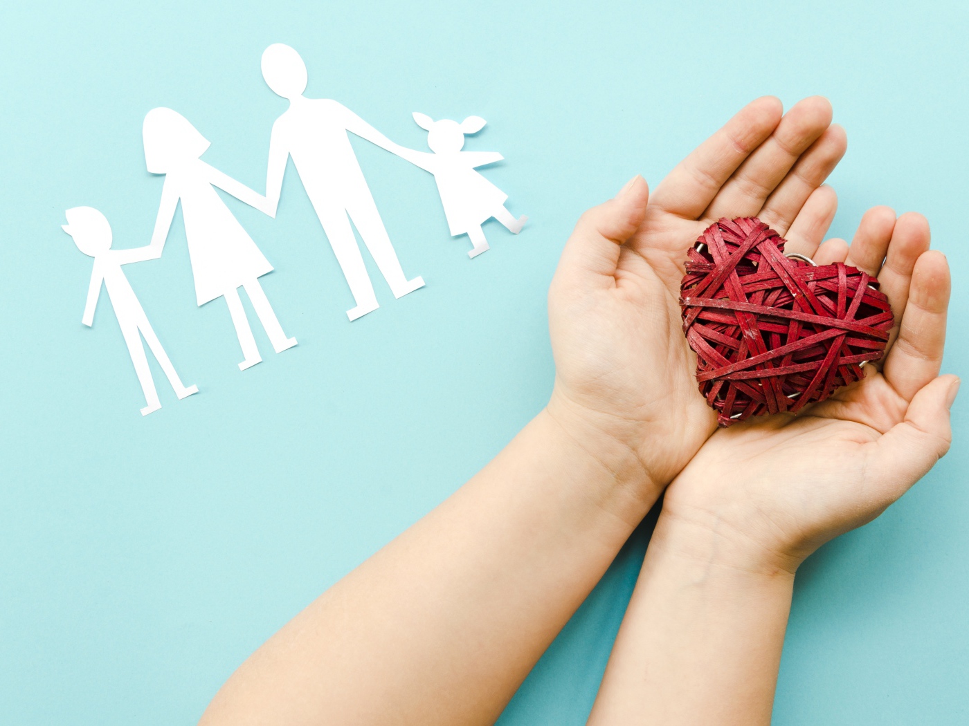 Плетеное сердце в руках на голубом фоне