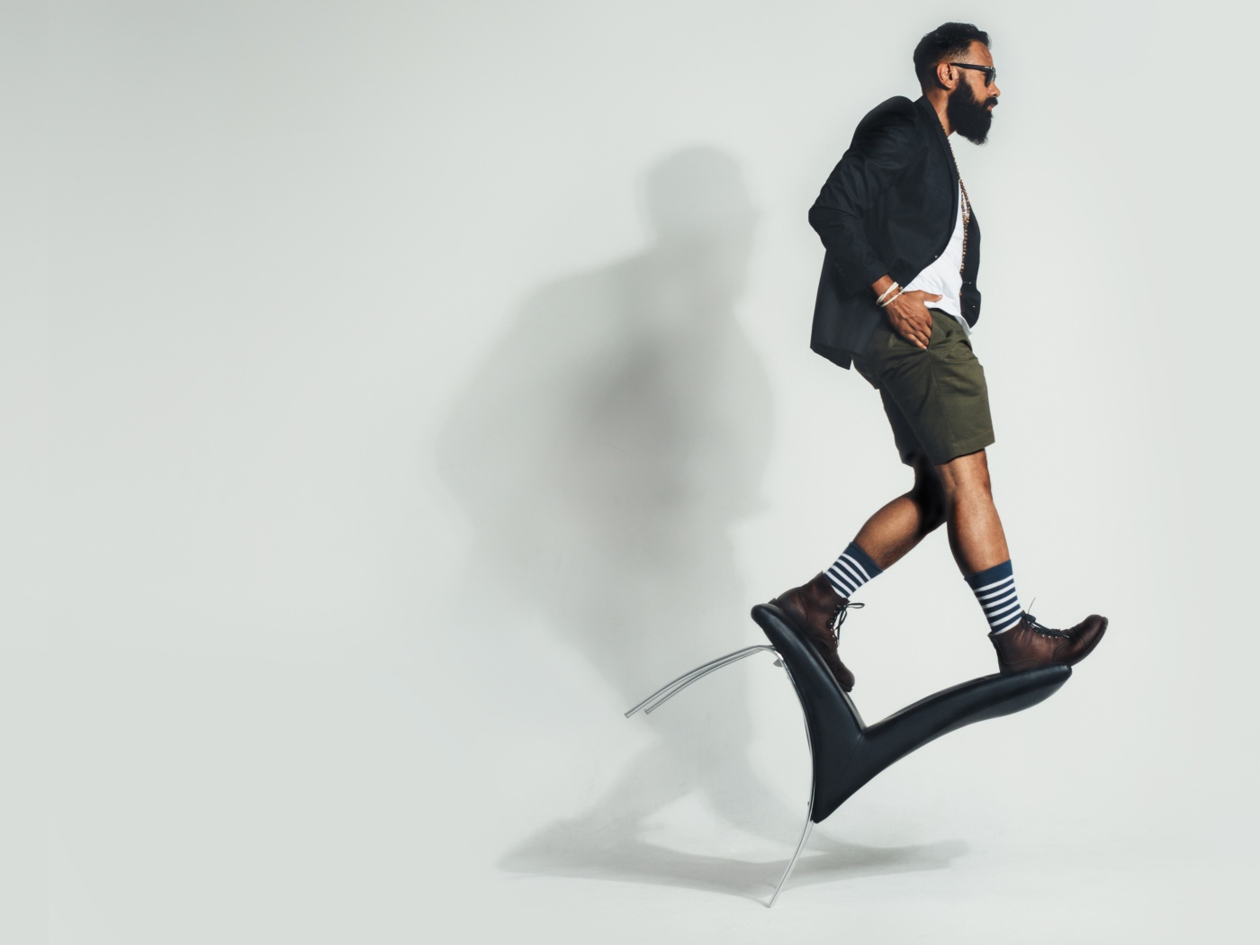 Мужчина балансирует на черном кресле