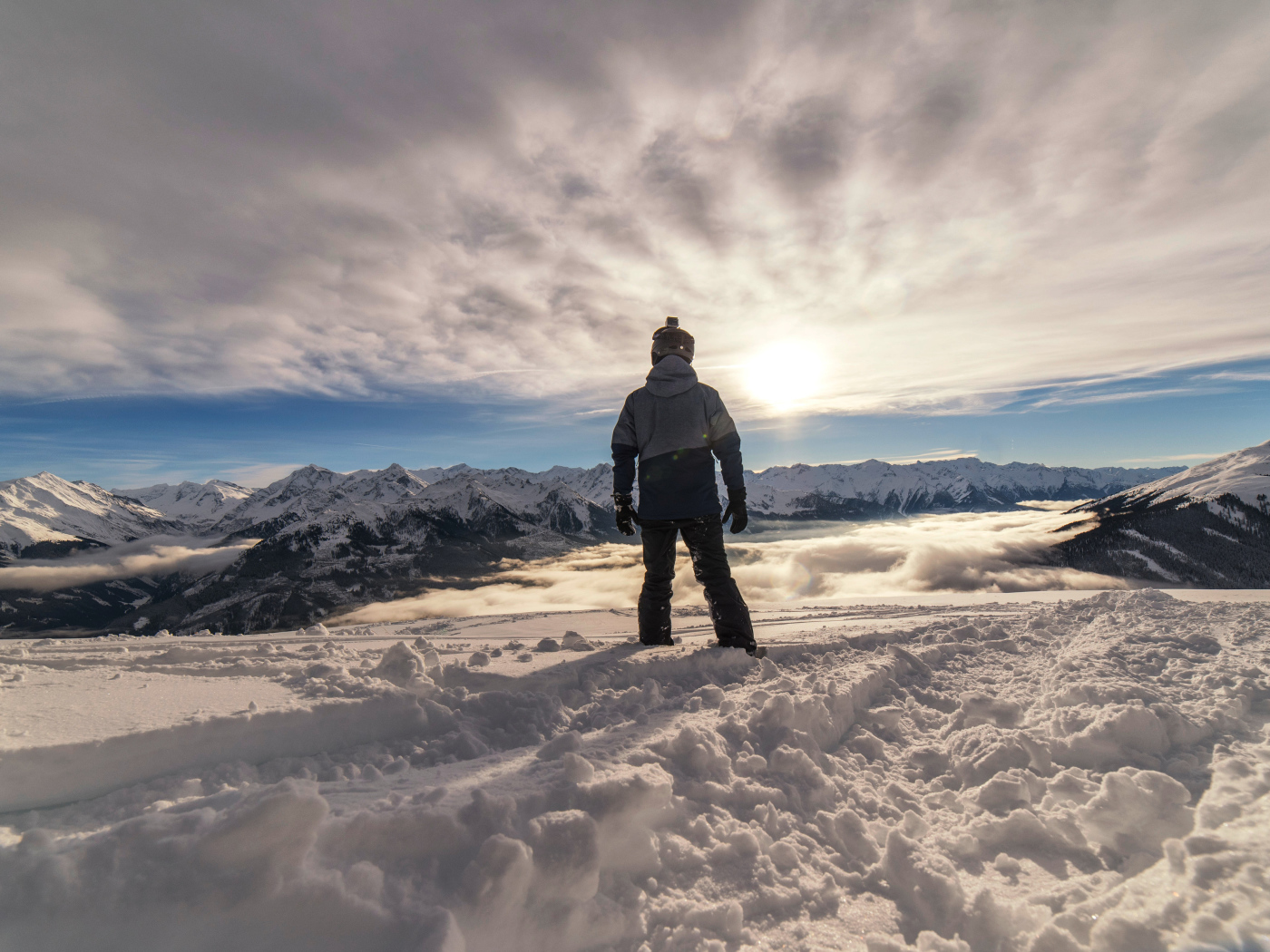 Человек в заснеженных горах в лучах солнца