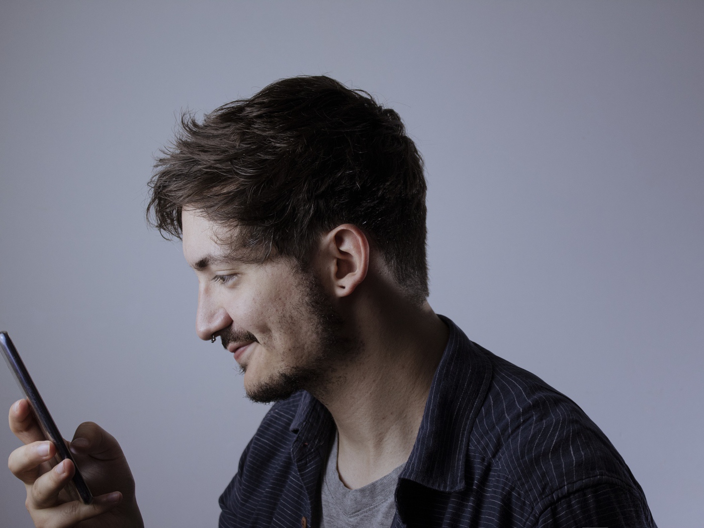 Мужчина с телефоном в руке на сером фоне 