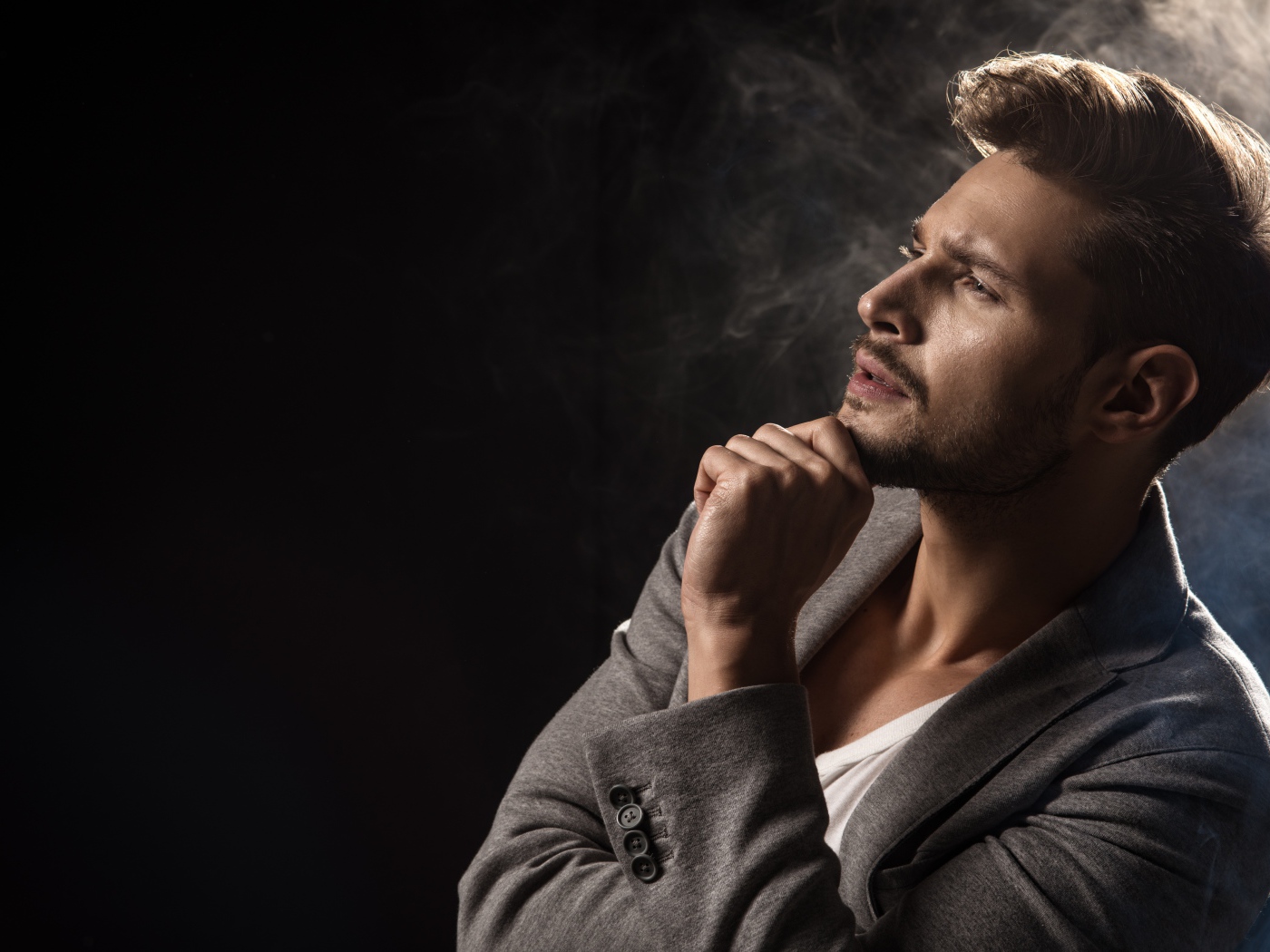 Задумчивый взгляд мужчины на черном фоне 