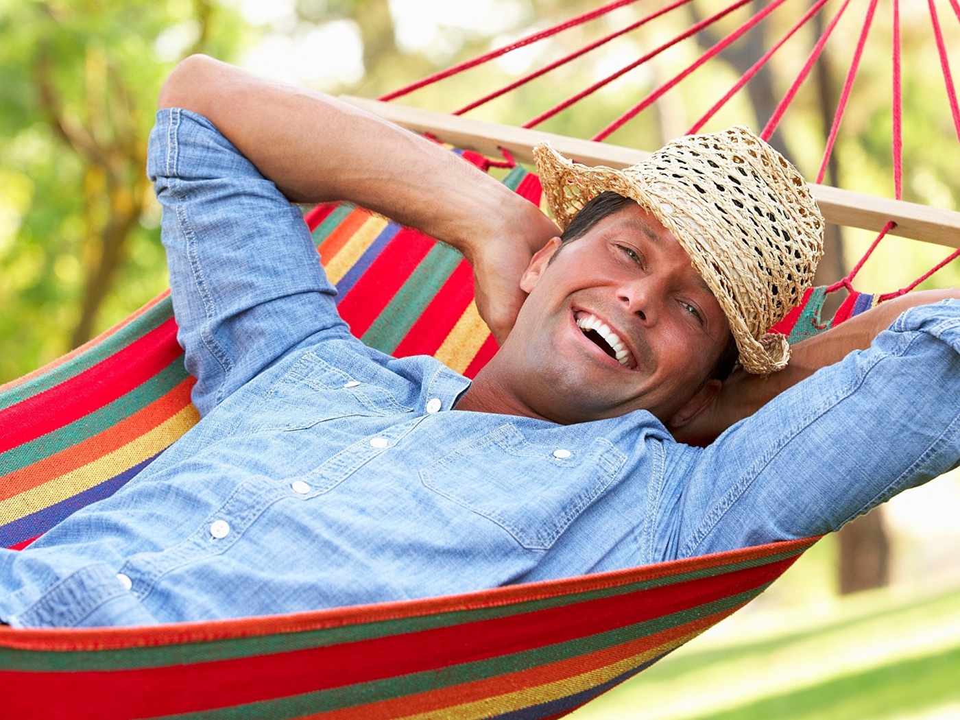 Улыбающийся мужчина спит в гамаке