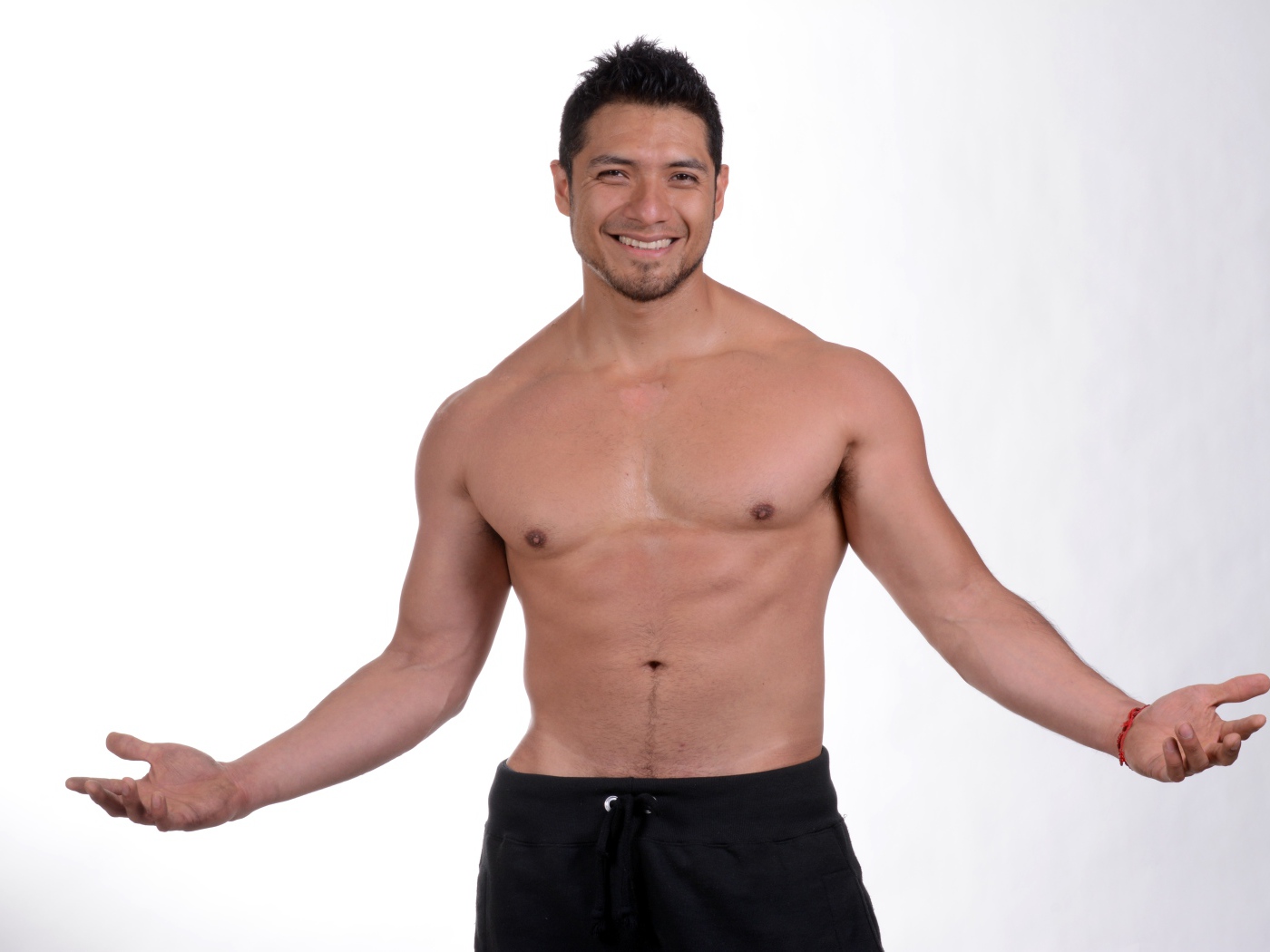 Улыбающийся накаченный мужчина на сером фоне