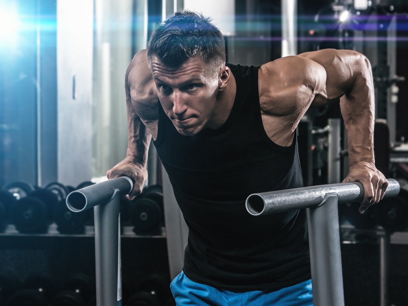 Сильный накаченный мужчина занимается в спортзале 