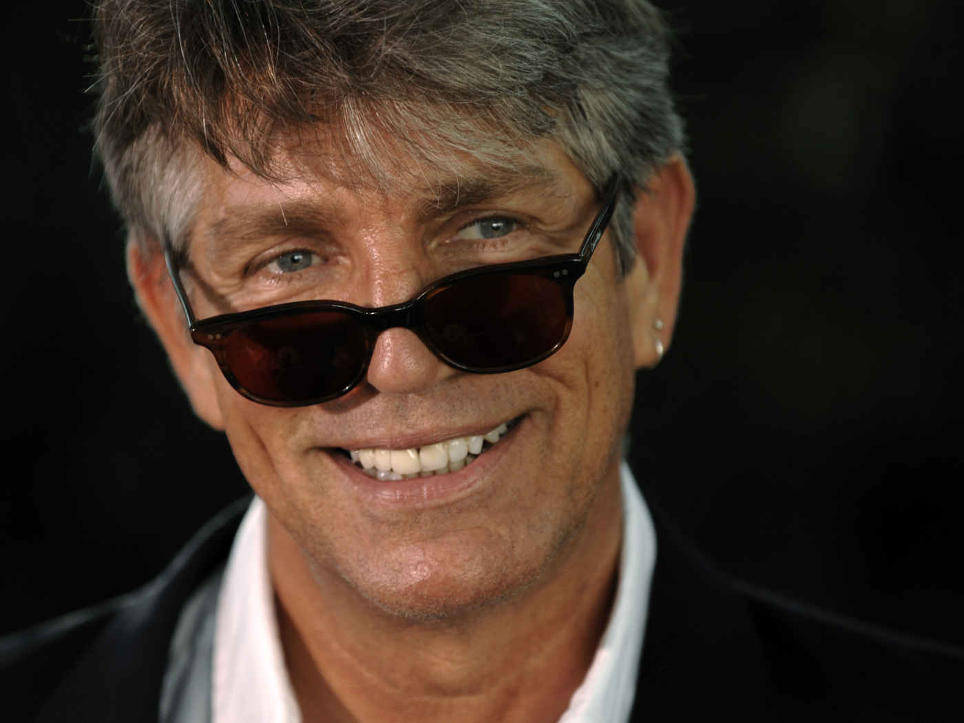 Актер Эрик Робертс в очках на черном фоне