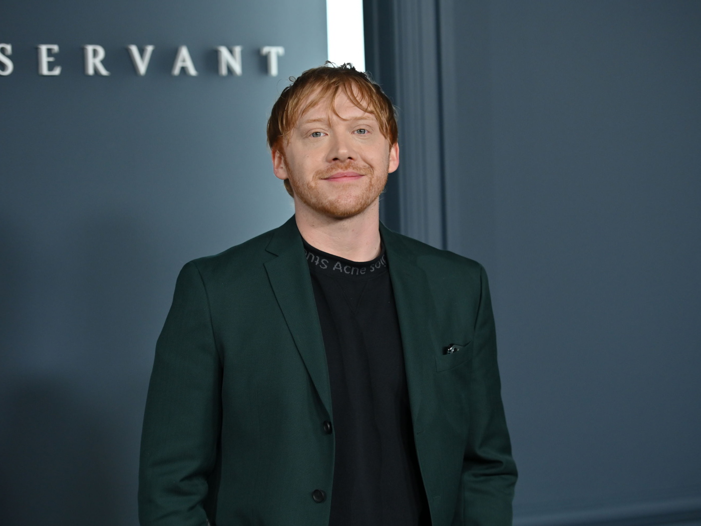 Актер Руперт Гринт на сером фоне