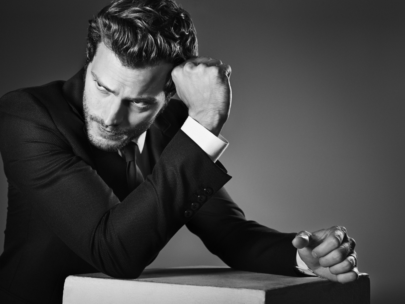 Британский актер Джейми Дорнан на сером фоне