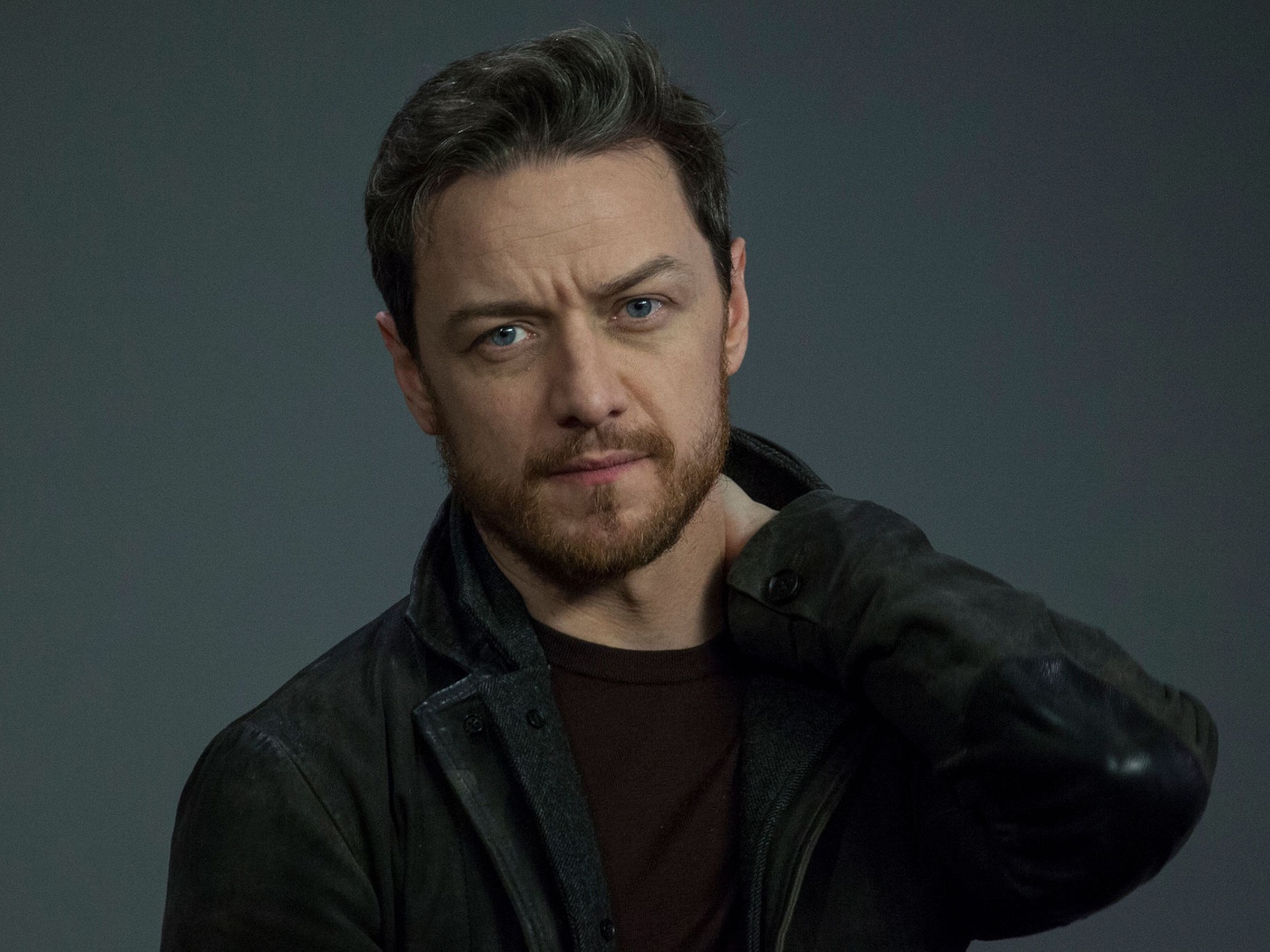 Красивый мужчина, актер Джеймс МакЭвой на сером фоне